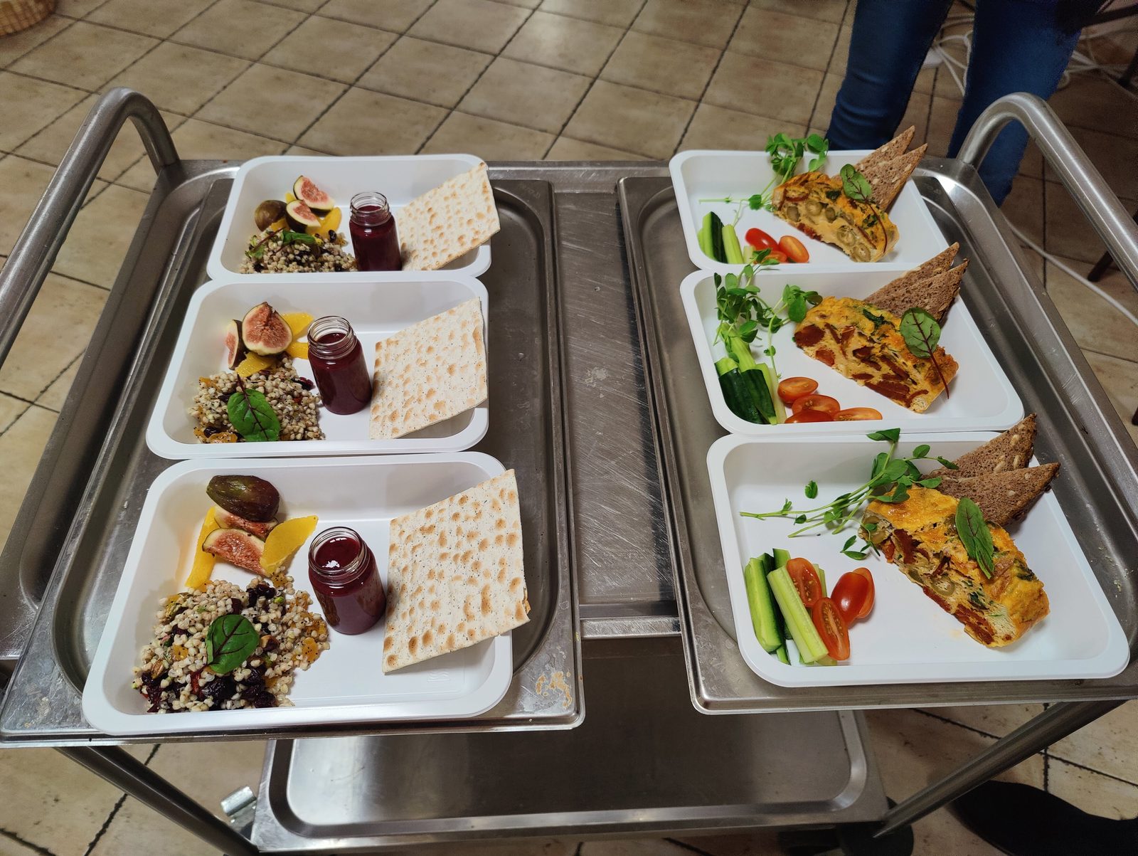 Real production kitchen with plated portions on prep carts