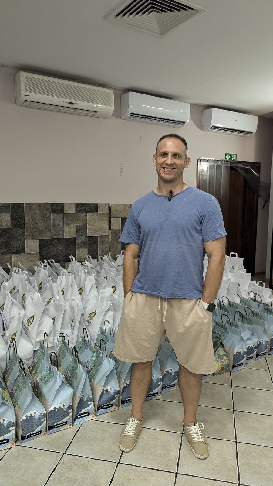 Founder standing beside rows of packed prepaid meal-delivery bags